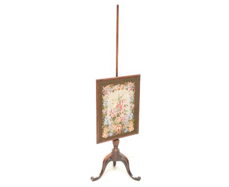 An Edwardian mahogany pole screen with tripod supports, with later tapestry in carved rectangular frame.