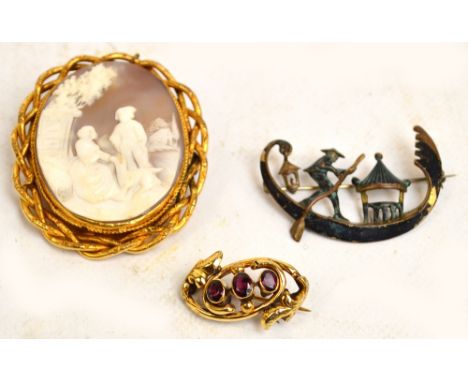 A Victorian yellow metal foliate scroll decorated brooch set with three oval garnets, an oval yellow base metal mounted cameo