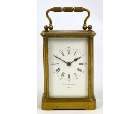 A c.1900 French brass cased carriage clock with swing loop handle above rectangular white enamel dial set with Roman numerals
