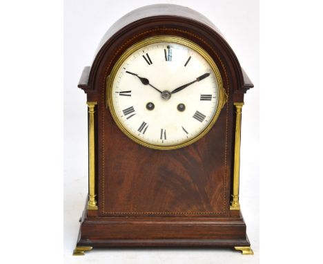 An Edwardian mahogany and inlaid mantel clock, the circular enamel dial set with Roman numerals flanked by gilt columns, eigh