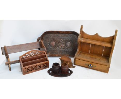 A collection of carved treen objects including a tray decorated with an elephant, a tree trunk box and cover, a book rack, a 