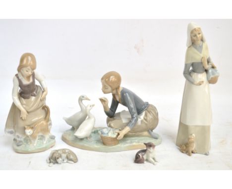 Five Lladro figures; a girl with two geese, a girl with a puppy, a girl with a cat, a small figure of a recumbent dog and a f