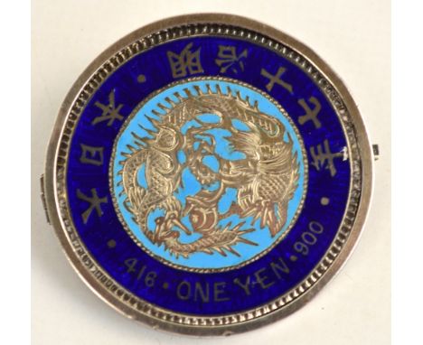 A Japanese Meiji 1 yen silver coin decorated with blue enamel and converted to a brooch. CONDITION REPORT: Small chip to the 