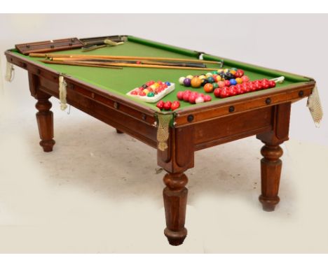 A late Victorian mahogany three quarter size slate bedded snooker table with shaped baluster legs, with scoreboard, balls, an