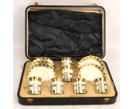 An early 20th century Aynsley floral decorated gilt heightened cased six setting coffee service, the coffee cans held in Geor
