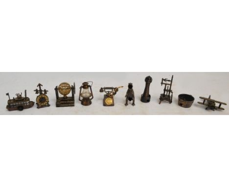 A collection of metal pencil sharpeners including examples in the form of a lighthouse, a biplane, a telephone, a dinosaur, a