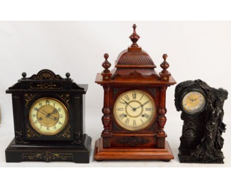 A German ebonised mantel clock, the circular dial set with Roman numerals flanked by two fluted columns, height 36cm, an oak 