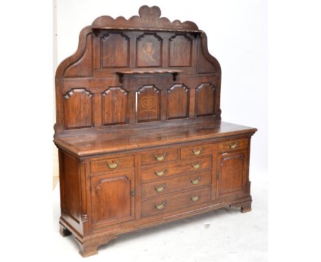 An early 19th century oak dresser, probably Scottish, the raised back inlaid with a thistle and crown and "Scotorum" beneath 