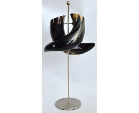 An unusual double section cow horn vase raised on brushed steel stand, height 70cm.