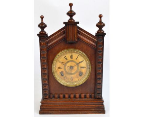 An American walnut cased Ansonia eight day mantel clock, with arched pediment and circular dial set with Roman numerals, heig