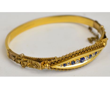 An Edwardian 15ct yellow gold snap bangle with safety chain set with five graduated sapphires alternating six graduated diamo