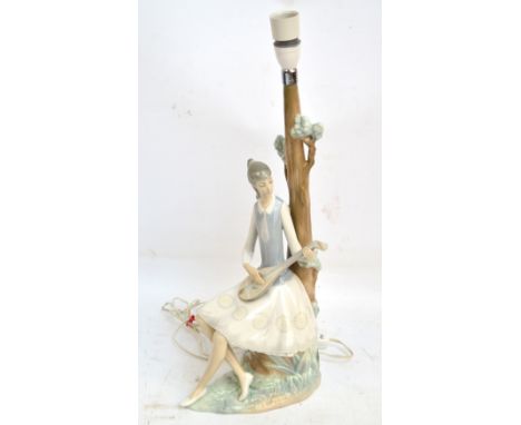 A Lladro Daisa lamp in the form of a woman playing a mandolin under a tree, marked to base, height 53cm including fitting (af