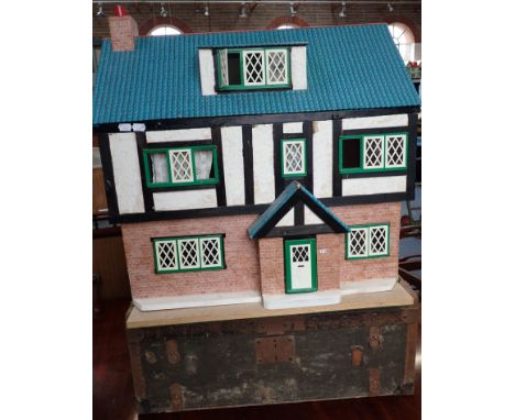A DOLL'S HOUSE with a few furnishings, 67 cm wide and a small travelling trunk