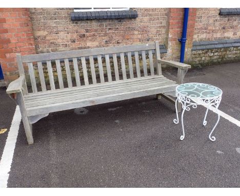 A LARGE TEAK GARDEN BENCH 194 cm LONG (weathered,one broken stretcher) and a small metal framed garden table