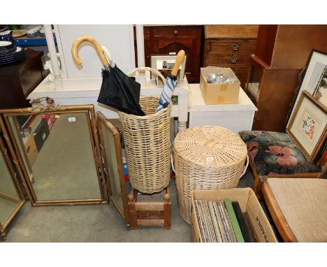 A wicker laundry basket; a wicker stick stand; a wooden crate and various umbrellas 