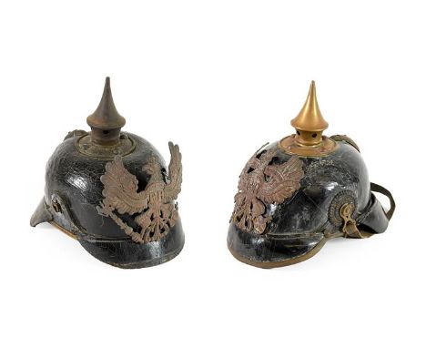 Two First World War Prussian Pickelhauben, each of leather construction with stamped copper helmet plates and leather liner, 