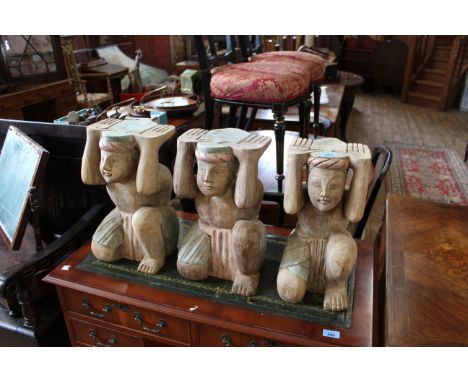 Three carved kneeling figure pedestals for bench/table originally