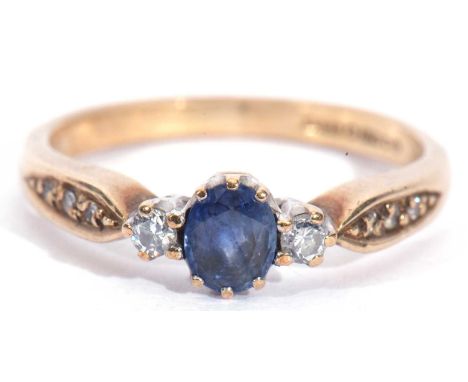 9ct gold sapphire and diamond three stone ring, the oval shaped small faceted sapphire flanked by two small brilliant cut dia