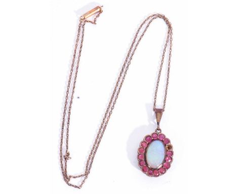 Opal and ruby pendant, the oval cabochon opal in cut down setting within a small ruby stone surround (one missing) suspended 