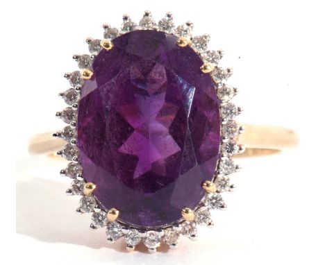 Modern 18ct gold amethyst and diamond ring, the oval faceted amethyst set within a small diamond surround, all in a basket mo