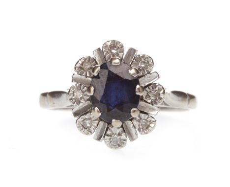 GEM SET CLUSTER RINGset with an oval blue stone 7.5 mm long, surrounded by illusion set round white gems, unmarked, shank mis