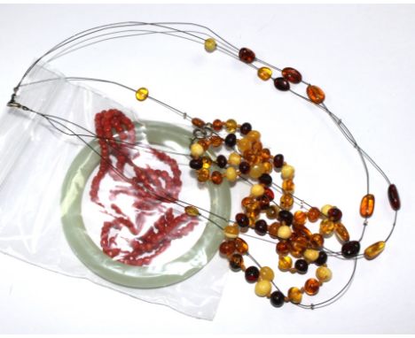 A jade bangle, a coral necklace and an amber necklace