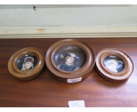 A set of three Viennese style ceramic plaques depicting portraits of ladies, in timber frames, 14cm diameter and 10.5cm diame