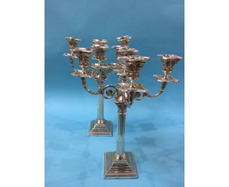 Pair of silver four branch candelabra, with Corinthian columns, the fluted and reeded columns supported on stepped square bea