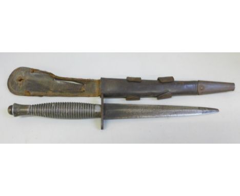 A Fairbairn-Sykes Commando fighting knife and scabbard, ring grip pattern, broad arrow over '4' on the handle, tip a/f **PLEA