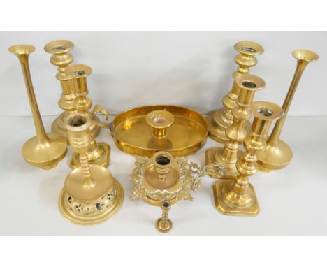 A collection of eight brass candlesticks (three matching pairs) with two chamber-sticks and another miniature candlestick. 