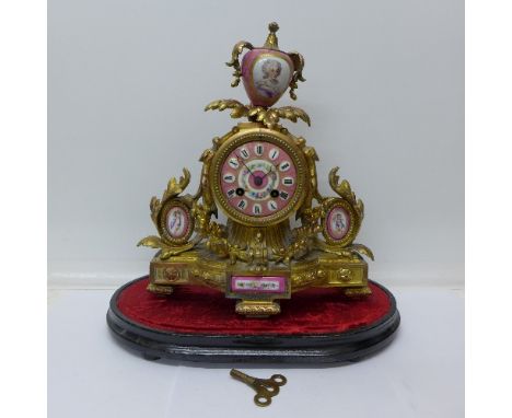 A 19th Century gilt metal Rococo style French clock with key and pendulum