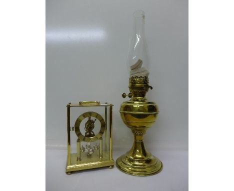 A brass oil lamp and a German made brass anniversary clock