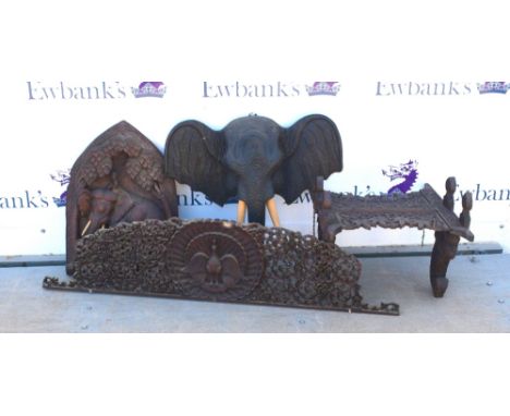 Collection of Indian hardwood carvings, to include an ebonised wall panel with an elephant bust with wooden tusks, a floral c