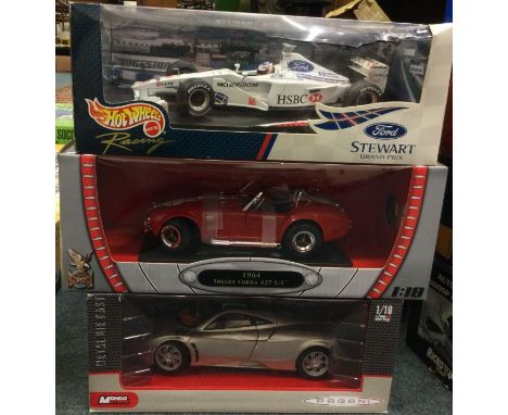Three boxed 1:18 scale model cars. Est. £20 - £30.