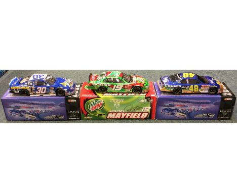 Three various 1:24 scale boxed model race cars. Est. £20 - £30.
