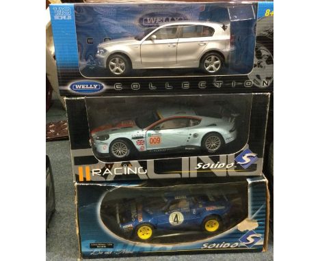 Three boxed 1:18 scale model cars. Est. £20 - £30.