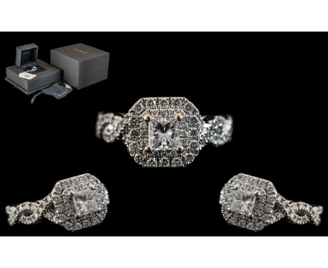 An 18ct White Gold Diamond Ring, set with a central Princess cut diamond, surrounded by round brilliant cut diamonds, round c