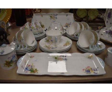 A 1930s Shelley 'Wild Flowers' part tea service, having Gainsborough shaped cups, saucers,sandwich plates/platters, lidded pr