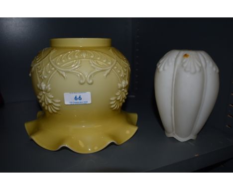 Two vintage glass lamp shades, one having embossed floral detailing and fluted edges.