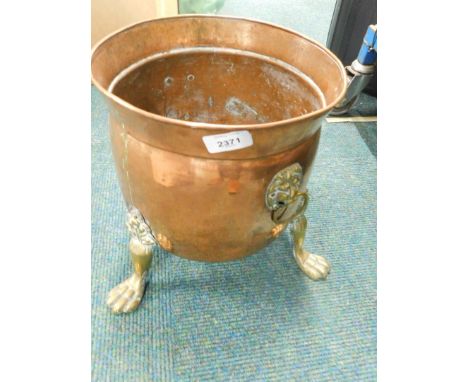 A copper and brass coal bucket, with lion mask handles, on tripod base. 