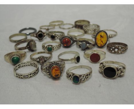 A selection of white metal dress rings of various designs including Baltic Amber, Celtic knot etc