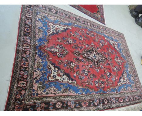 A mid 20th century carpet square of Eastern floral design on red ground, approx 120in x 84in