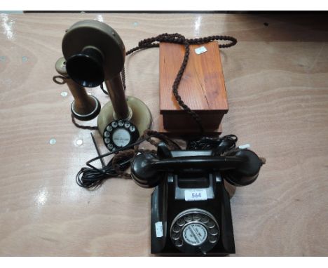 A 1950s design bakelite G.P.O 'Deal or no Deal' telephone, and a reproduction brass candlestick telephone