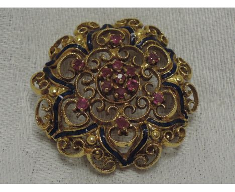 An 18ct gold brooch having ruby and enamel decoration in an open mount. approx 9.4g