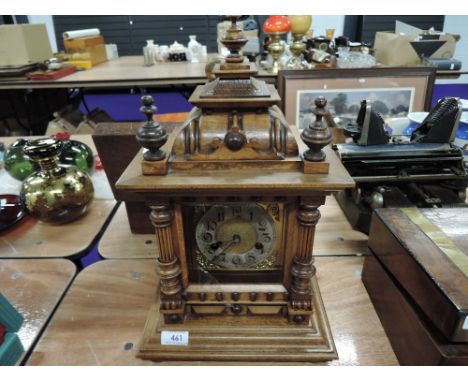 An early 20th century light mahogany cased German mantel clock of architectural form having spindles and pillars, containing 