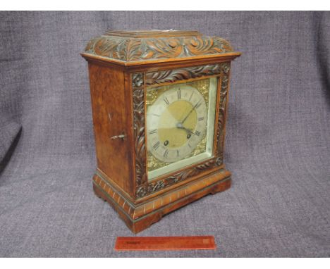 An early 20th century walnut cased mantel clock having acanthus carved decoration with silvered and brass spandel, Roman nume