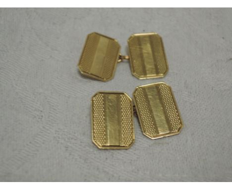 A pair of 9ct gold cufflinks of canted rectangular form having engine turned decoration and chain connectors.&nbsp; approx 4.