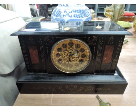 A 19th century black marble mantel clock having incised decoration and rouge marble insets with gilt brass pierced face by Th