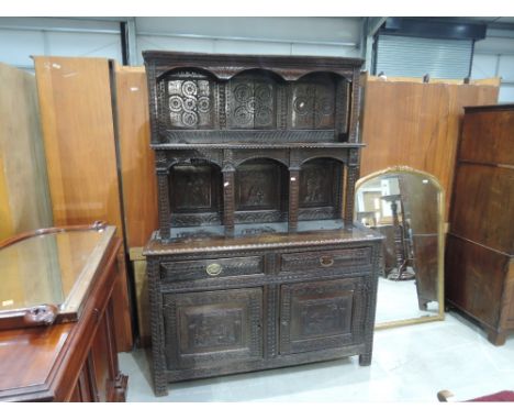An 18th century and later oak composite tridarn cupboard having extensive lunette and medieval pictorial style decoration wit