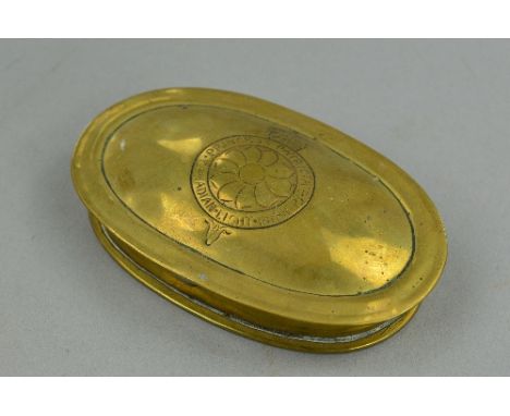 A HANDMADE BRASS TIN, in oval shape, with hinge lid from the WWI era (Trench Art style) with a hand crafted insignia to the l